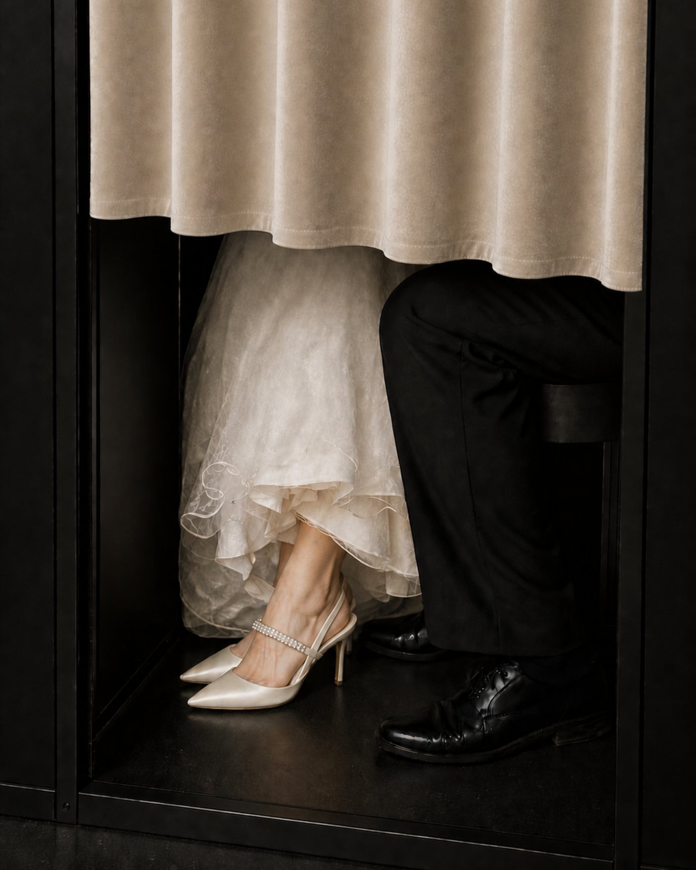 Los novios dentro de la cabina, vistos desde debajo de la cortina